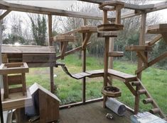 a wooden bird house with several birds in it's cage and some other things on the ground