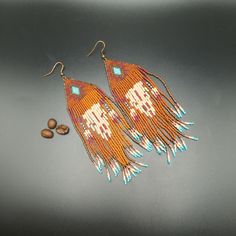 Hand beaded earrings with a bull skull pattern.  These earrings are made with tiny cylindrical beads and bead thread.  The beads are brown, ecru, and turquoise.  The ear wire is brass in color (nickel and lead free).  4.25" x 1.25" Hand beaded by me, Pattern by BeadingPatterns4Fun. Adjustable Brown Beaded Earrings For Festival, Artisan Brown Beaded Earrings For Pierced Ears, Brown Dangle Beaded Earrings With Tiny Beads, Traditional Brown Beaded Earrings With Tiny Beads, Brown Round Bead Earrings For Festivals, Adjustable Brown Earrings With Beaded Fringe, Brown Beaded Dangling Earrings For Festival, Brown Dangling Beaded Earrings For Festivals, Festival Brown Earrings With Colorful Beads