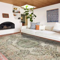 a living room filled with furniture and a rug on top of a hard wood floor