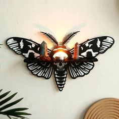 a light that is on the side of a wall with a butterfly shaped light in it