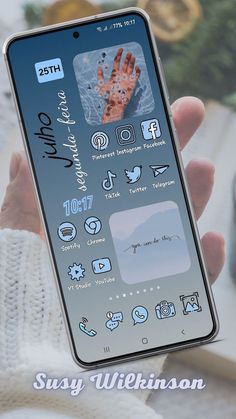 a person holding up a phone with icons on the screen and an image of someone's hand