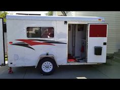 a white and red trailer parked in front of a house