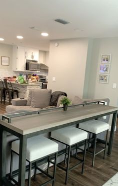 a kitchen and living room are separated by a bar in the middle of the floor