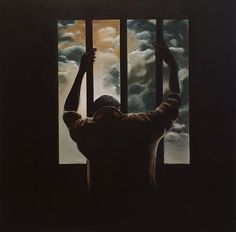 a man standing in front of a window holding his hands up to the sky and clouds