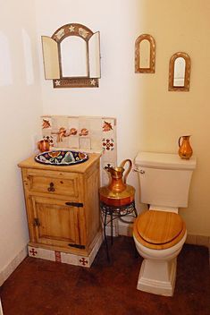 a bathroom with a toilet, sink and mirror