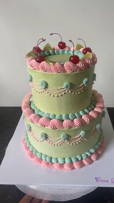 a three tiered cake with cherries on top