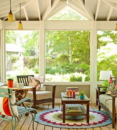 an enclosed porch with chairs, tables and couches