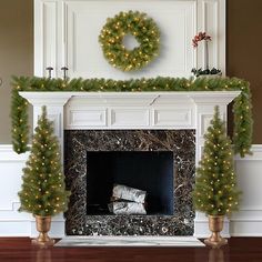 a fireplace decorated for christmas with wreath and lights