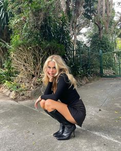 a woman kneeling down on the ground with her legs crossed