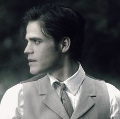 a man in a suit and tie looking off into the distance