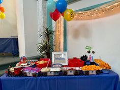 a table topped with lots of food and balloons