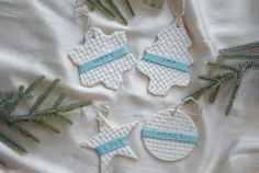 three christmas ornaments are hanging on a white sheet