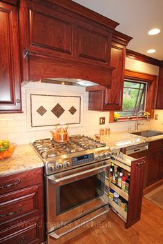 a stove top oven sitting inside of a kitchen next to wooden cabinets and counter tops