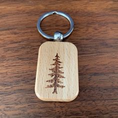 a wooden keychain with a pine tree engraved on it