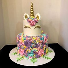 there is a cake that looks like a unicorn's head on top of it