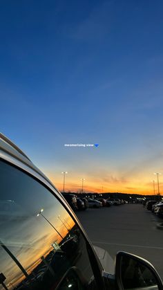 the sun is setting over a parking lot with many cars parked in it and there are no clouds