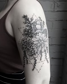 a black and white photo of a woman's arm with flowers on it