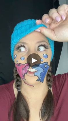 a woman with her face painted in blue and pink