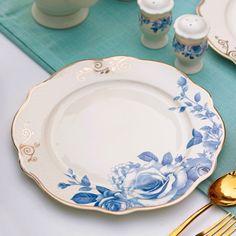 a blue and white table setting with goldware