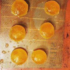 four oranges sitting on top of a baking sheet