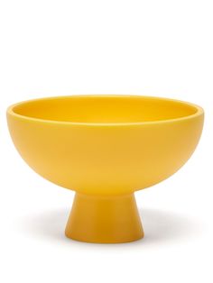 a yellow bowl sitting on top of a white table