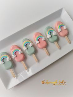 there are four rainbow lollipops on the plate