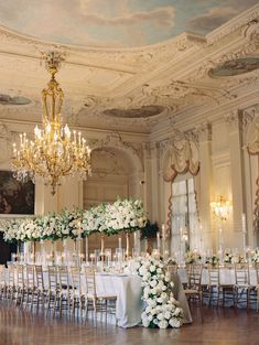 an elegant ballroom with chandeliers and white flowers