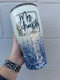 a hand holding up a blue and white glittered tumbler with the words mrs sequin on it