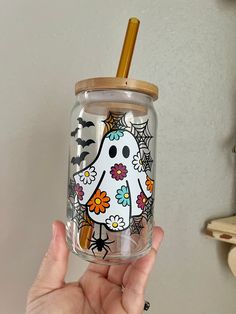 a person holding up a glass with a stick in it's mouth and an image of a ghost on the inside