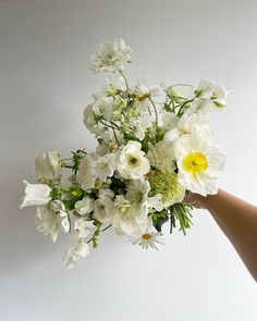 a hand holding a bouquet of white flowers