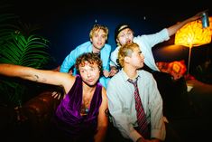 four young men posing for a photo in front of a lamp