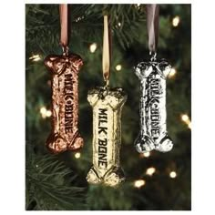 three dog bone ornaments hanging from a christmas tree