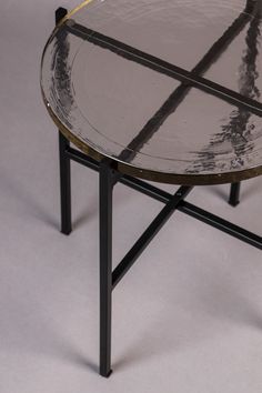 a round glass table with black metal legs