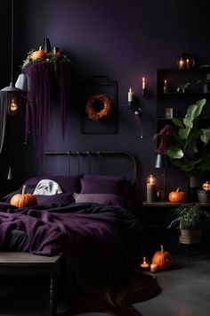 a bedroom decorated in purple and black with pumpkins on the bed, candles and decorations