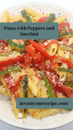 pasta with peppers and zucchini served on a white plate topped with parmesan cheese