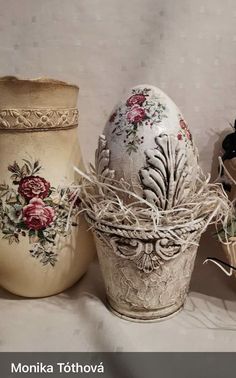 three vases with flowers painted on them sitting next to each other