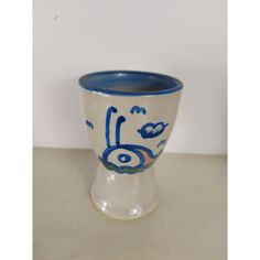 a blue and white vase sitting on top of a table next to a white wall