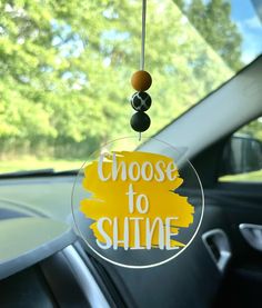 a close up of a car's dashboard with a sign that says choose to shine