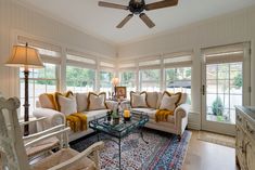 a living room filled with furniture and windows