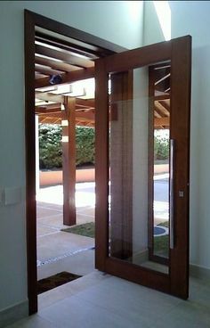 an open wooden door with glass panels on the outside