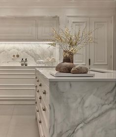 a kitchen with marble counter tops and white cabinets