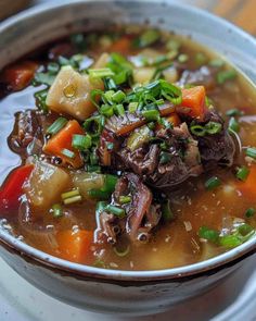 a close up of a bowl of food with meat and veggies in it