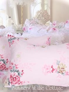 a bed with pink flowers and ruffles on the pillowcase is shown in front of a mirror