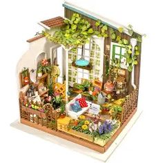 a doll house with lots of furniture and flowers on the outside, including a patio