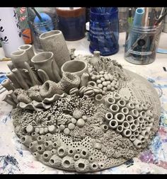 a sculpture made out of clay sitting on top of a table next to other art supplies