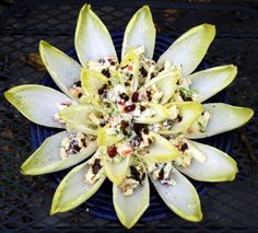 a close up of a flower on a blue plate with other flowers in the background