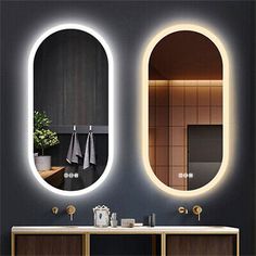 a bathroom with two oval mirrors above the sinks and a mirror on the wall behind it