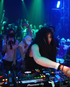 a dj mixing music in front of a crowd