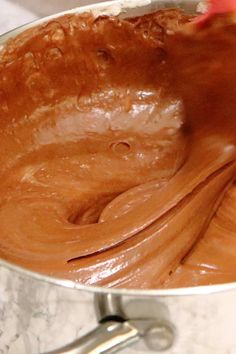 a person mixing chocolate in a silver bowl