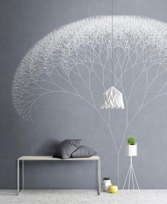 a white bed sitting next to a gray wall with a tree on it's side